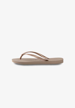 Smeđe gumene japanke s tekstrurom potplata i tankim trakama. Imaju uzdignuti uzorak na trakama i ravni, podstavljeni đon.