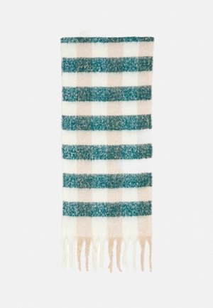 Écharpe en laine douce avec un large motif à carreaux vert, beige et blanc, avec des extrémités à franges sur un fond blanc.