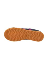 Black shoe sole with herringbone pattern, featuring a textured orange rubber base. Prominent logo centered on the sole.