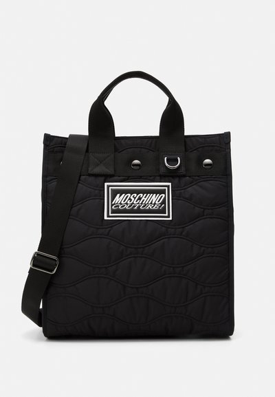 Borsa tote nera trapuntata con doppi manici superiori, tracolla regolabile e una patch con logo bianco. Caratterizzata da una texture liscia e dettagli in argento.