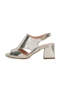 Metallic gold Slingback-High Heels mit offener Zehenpartie, reptilartiger Textur, breiten Vorderausschnitten und Blockabsatz. Schnallendetail am Knöchel.