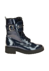 Marineblauwe patenten leren enkellaarsjes met een vetersluiting aan de voorkant, een decoratieve band met studs en een chunky zwarte zool. Gladde afwerking, mid-cut ontwerp.