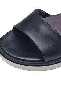 Sandale glissière en cuir bleu marine avec une large bande lisse, bout ouvert, semelle intérieure rembourrée et semelle blanche contrastante.