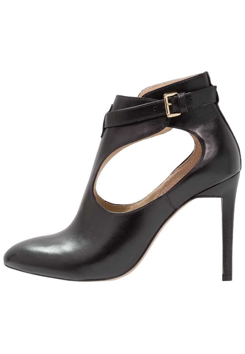 Černá kožená kotníková bota s špičatou špičkou, otevřenými stranami a jedním přezkovým popruhem. Disponuje lesklým povrchem a jehlovým podpatkem.