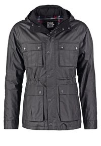 Czarna wodoodporna kurtka z kapturem, wieloma przednimi kieszeniami, zatrzaskami i w kratę podszewką. Wykonana z trwałego materiału o gładkiej fakturze.