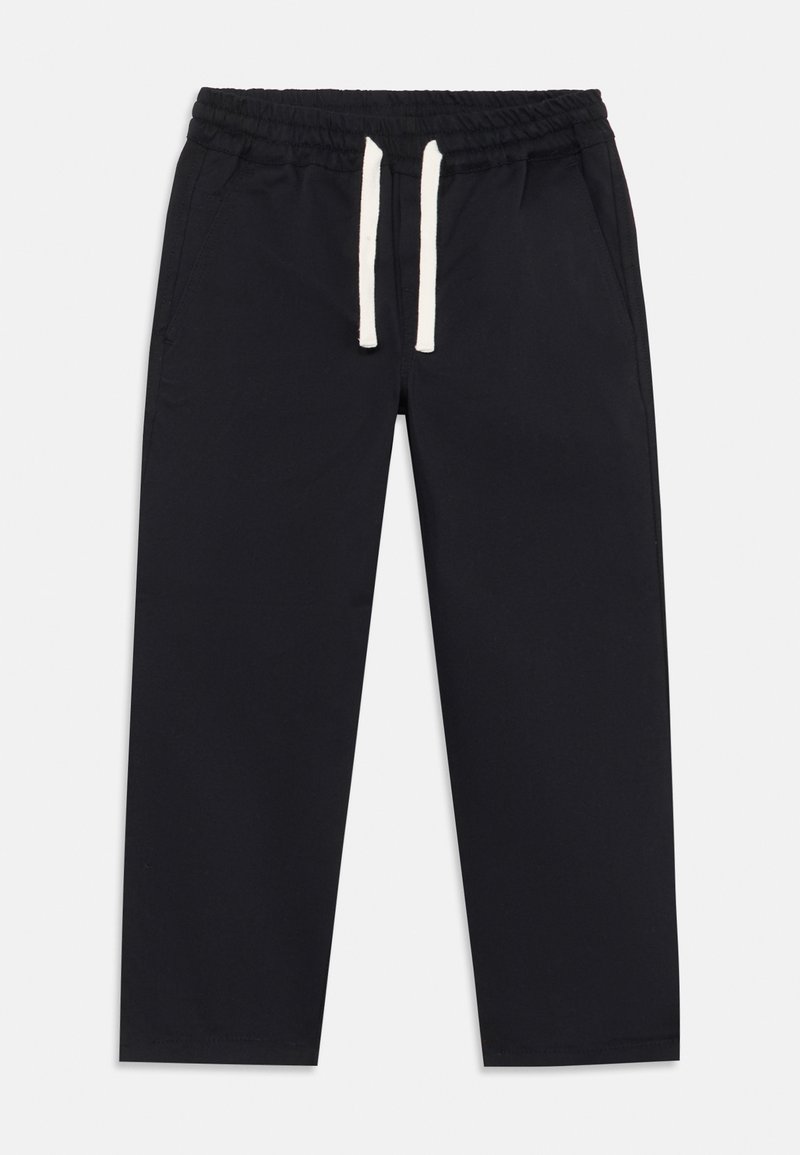 Schwarze Jogginghosen mit elastischem Bund, weißen Kordeln, seitlichen Taschen und einer glatten Stofftextur. design in kürzerer Länge.