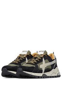 Sneaker multicolori con una tomaia in suede nero e rete verde oliva, caratterizzati da una croce riflettente in argento, accenti beige e una suola maculata.