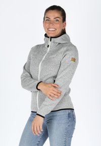 Gray zip-up hoodie with a high collar, black accents, and a textured finish. Features a small branded patch on the left sleeve.