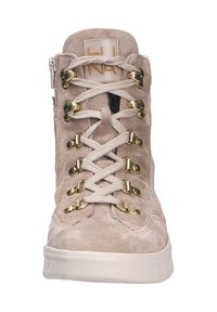 Botte en suède beige avec des détails en or, présentant un design montante, un bout rond et un laçage à l'avant avec des œillets décoratifs pour un maintien sûr.