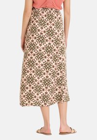 Falda de longitud media en una tela rosa suave con un patrón geométrico en verde y burdeos. Cintura elástica ligera y un corte relajado.