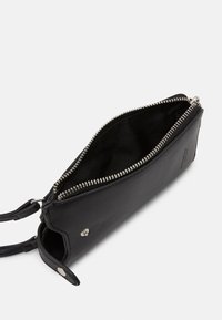 Clutch nera in pelle con zip, dalla superficie liscia, foderata in tessuto e con hardware in argento. Dotata di una tracolla rimovibile e chiusura a bottone.