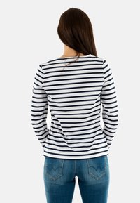 Maglietta a maniche lunghe in tessuto bianco con righe orizzontali blu navy, caratterizzata da un colletto rotondo, vestibilità slim e vista posteriore. Abbinata a jeans blu.