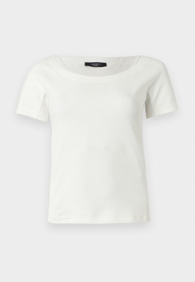 Λευκό γυναικείο βαμβακερό τοπ με κοντά μανίκια και φαρδύ στρογγυλό λαιμόκοψη σε απλό ανοιχτό φόντο.