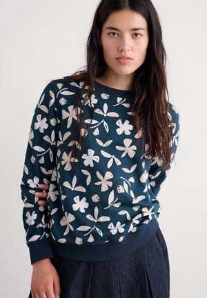 Marineblauwe sweatshirt met witte bloem- en loofpatronen, geribbelde ronde hals en manchetten. Zachte stof met een relaxte pasvorm.