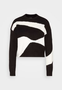 Svart och vit kortad tröja med ett vågmönster, ribbade ärmslut och rund halsringning i ett mjukt stickat material.