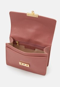 Rosa Leder-Clutch mit strukturiertem Oberflächen, goldenem Hardware-Verschluss und einem Reißverschluss-Innenfach. Mit einer Außentasche.
