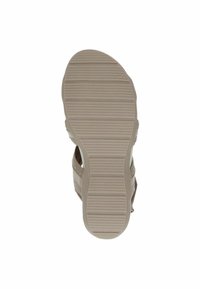 Semelle de sandale avec un motif texturé, comportant des rainures pour une meilleure adhérence. Fabriquée en caoutchouc de couleur beige clair, conçue pour le confort et la stabilité.