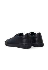 Zwarte leren sneakers met een gladde afwerking, laag ontwerp, ronde neus en een gestructureerde rubberen zool. Voorzien van veters en minimale stikseldetails.