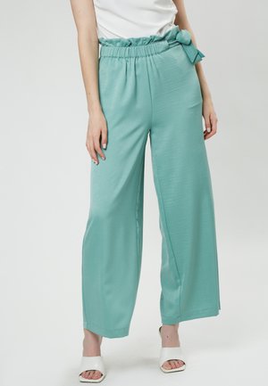 Lichtblauwe wijde broek met een gerimpelde, elastische tailleband en een strikdetail bij de taille, met een gladde, licht glanzende textuur.