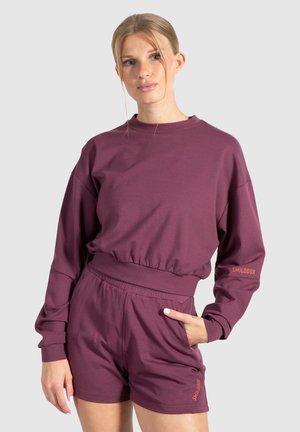 Maroon sweatshirt with a crew neckline and elastic waistband, paired with matching shorts featuring side pockets and an embroidered logo.