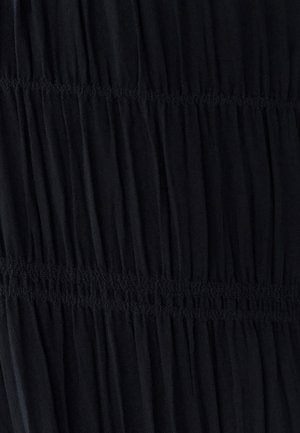 Robe noire avec texture plissée et froncée, taille élastique ; présente des lignes de couture verticales pour plus de détails.