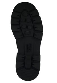 Black rubber shoe sole with deep tread patterns, hexagonal lugs, and ridged accents for enhanced traction and durability.