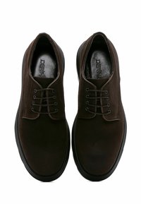 Chaussures habillées en daim marron avec une texture lisse, bout rond et un système de laçage à six oeillets. Semelles en caoutchouc noires et logo de la marque visible à l'intérieur.