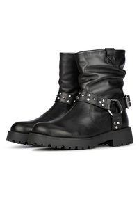 Botas de cuero negras hasta el tobillo con un diseño caído, correa con tachuelas plateadas y una suela de goma gruesa con un dibujo en relieve.