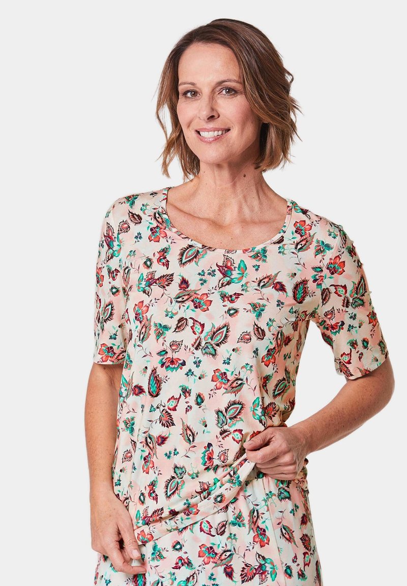 Bloemenblouse van zacht, lichtgewicht materiaal met korte mouwen, een ronde halslijn en een kleurrijk patroon van bloemen in rood, groen en blauw.