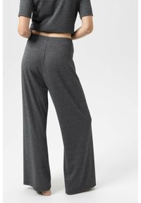 Grijze broek met wijde pijpen van zacht, gestructureerd materiaal, met een elastische tailleband en een soepel vallend ontwerp dat over de benen valt.