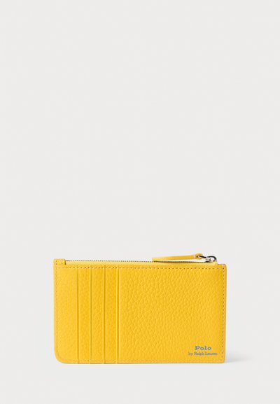 Cartera de cuero amarilla con un acabado texturizado, que cuenta con cuatro ranuras para tarjetas, un compartimento con cremallera y un detalle del logo en azul.