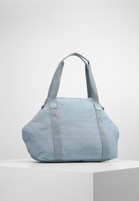 Sac cabas en tissu bleu de forme triangulaire, avec une surface texturée et deux poignées solides. Présente des accents gris contrastants sur les sangles.