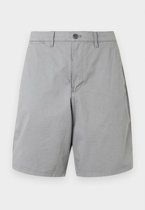 Pantaloni scurți gri deschis, până la genunchi, cu bucle pentru curea, închidere cu un buton și buzunare laterale, expuși pe un fundal alb simplu.