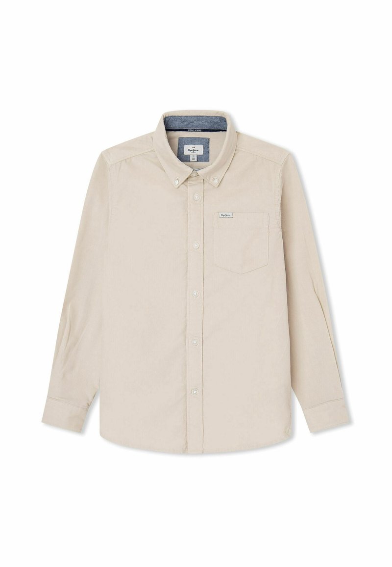 Chemise beige à manches longues avec boutons, col et poche poitrine, dotée d'une petite étiquette sur la poche et d'une doublure bleue à l’intérieur du col.