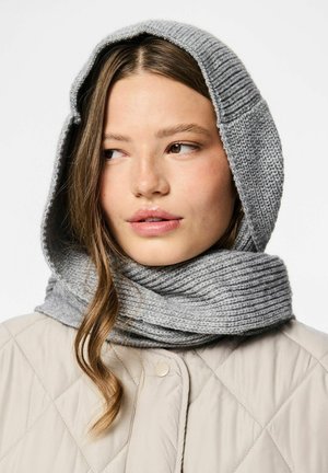 Sivo pleten šal z integrirano kapuco. Rebrasta tekstura, mehak material. Nosi se čez svetlo obloženo jakno.