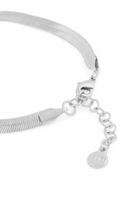 Silikometalhalsband med en flexibel design, en lås och en kedjeutmärkning med en rund tag-detail. Slät textur, blank yta.