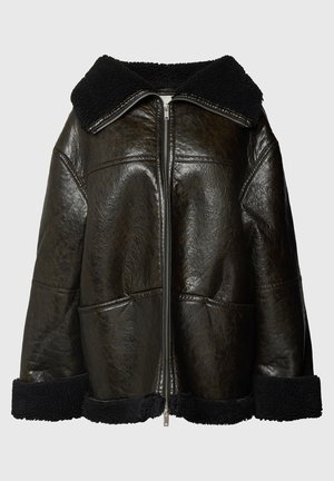 Smeđa kožna jakna s crnim ovčjim krznom oko ovratnika i rukava. Ima prednji patentni zatvarač i dva bočna džepa. Teksturalna završna obrada, oversized kroj.