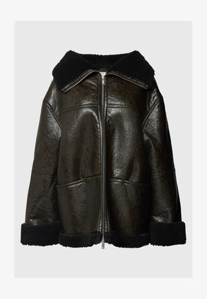 Hnědá kožená bunda s černým ovčími límcem a manžetami. Obsahuje přední zip a dvě postranní kapsy. Texturovaný povrch, oversize střih.