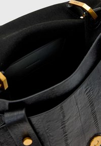 Borsa a tracolla nera in pelle con una finitura texture, accenti in hardware dorato e un ampio interno. Presenta una tasca interna liscia e foderata.