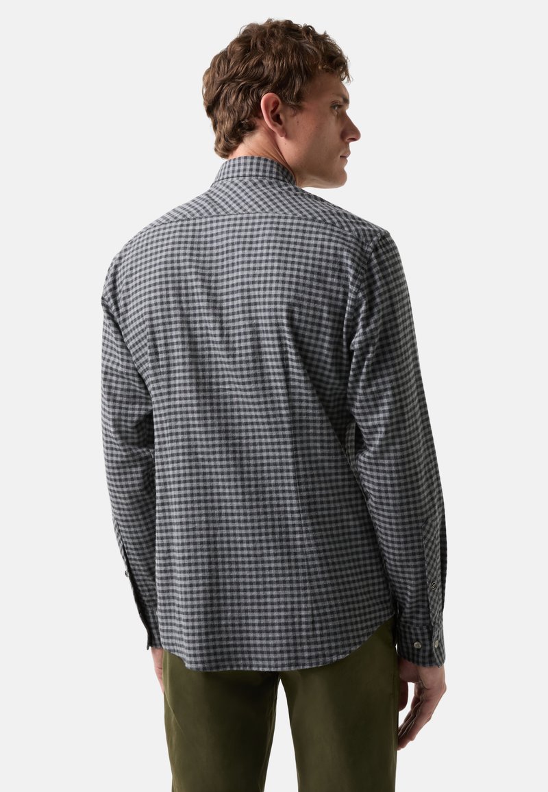 Grau-weißer karierten Hemd, lange Ärmel, mit Knopfmanschetten, Stoffstruktur sichtbar, klassischer Kragen, getragen mit olivgrünen Hosen.