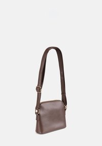 Borsa a mano in pelle marrone con forma rettangolare, tracolla regolabile e dettagli in zip dorato. Texture liscia con un design minimalista.
