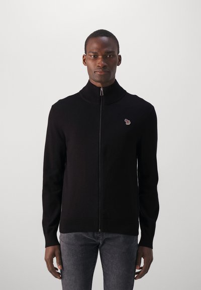 Black knitted zip-up sweater with a high collar and ribbed cuffs, featuring a small elephant logo on the left chest.
