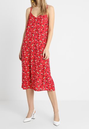 Robe d'été à imprimé floral rouge avec des bretelles fines et un décolleté en V, fabriquée en tissu léger, dotée d'une jupe mi-longue et d'une coupe décontractée.