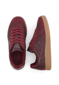 Burgundy sneakers with suede upper and sparkly fabric panels. Features gum rubber outsole and textured laces. Rounded toe and padded collar.