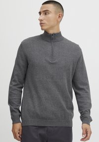 Gray sweater with a high collar and quarter zip. Ribbed cuffs and hem, made from a soft material, featuring a smooth texture and minimal detailing.