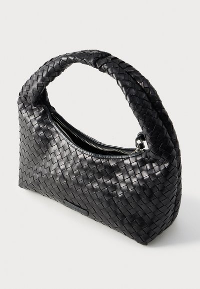 Μαύρη υφαντή δερμάτινη τσάντα χειρός με καμπυλωτή, πλεκτή λαβή και επάνω κλείσιμο με φερμουάρ. Ομαλή υφή με γυαλιστερό φινίρισμα.