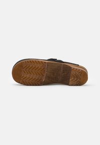 Sandal nero con tomaia nera texture, intersuola in legno e suola in gomma con motivo a spina di pesce. Design resistente e leggero.