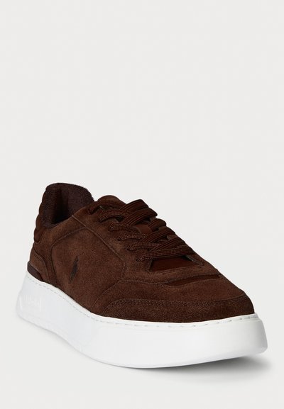 Adidași din suede maro cu șireturi maro închis și talpă groasă din cauciuc albă, inclinați pentru a arăta detalii din față și din lateral.