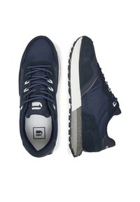 Tumši zili kedas, kas izgatavoti no gludas auduma un zamša, ar teksturētu pelēku zoli, kontrastējošām auklām un polsterētu apkakli.