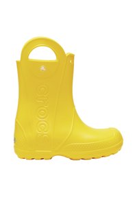 Bota de goma amarilla con punta redondeada, suela texturizada, asa para facilitar el uso y la palabra "crocs" grabada en el lateral.
